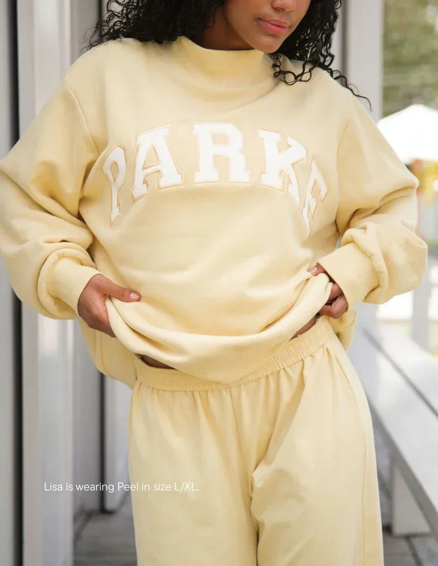 Women's oversized sweatshirt featuring soft chenille lettering, perfect for casual everyday wear and stylish comfort. 13